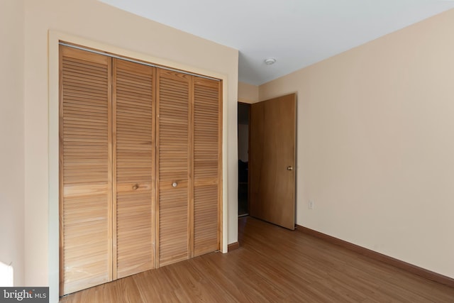 unfurnished bedroom with hardwood / wood-style floors and a closet