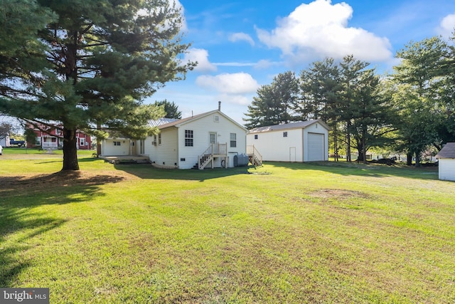 view of yard with a garage and an outbuilding