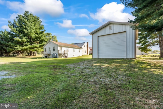 view of yard with a garage and an outbuilding