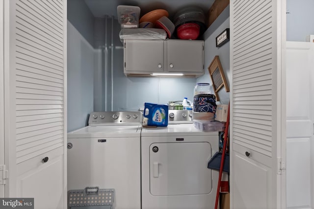 clothes washing area with cabinet space and independent washer and dryer