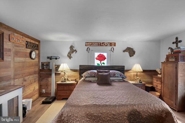 bedroom featuring wood finished floors and wooden walls