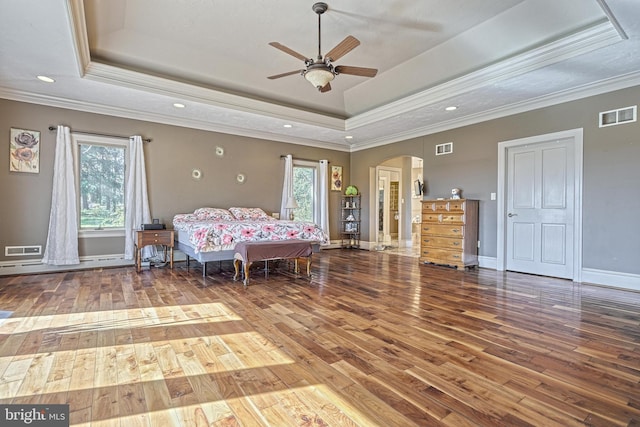 unfurnished bedroom featuring ceiling fan, a raised ceiling, crown molding, and hardwood / wood-style floors