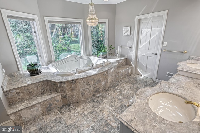 bathroom featuring vanity, tiled bath, and an inviting chandelier