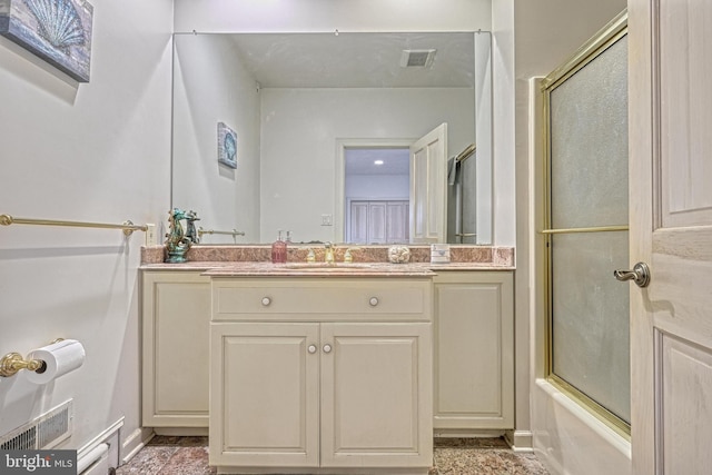 bathroom featuring vanity and combined bath / shower with glass door