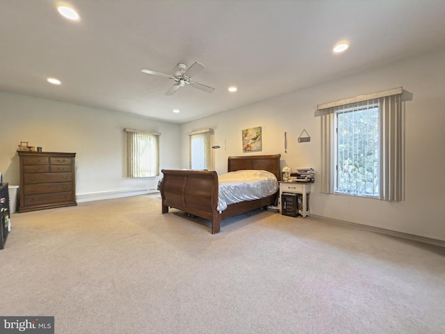 carpeted bedroom with ceiling fan and multiple windows