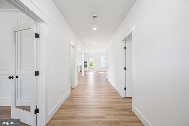 hallway with light hardwood / wood-style flooring