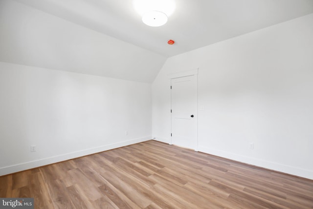 bonus room with vaulted ceiling and light wood-type flooring