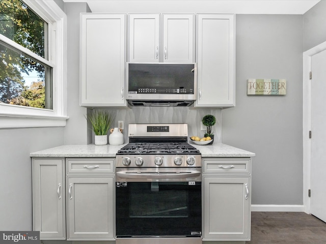 kitchen with white cabinetry, light stone counters, and stainless steel appliances