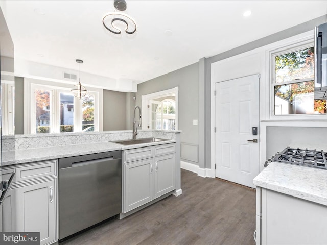 kitchen with hanging light fixtures, stainless steel appliances, sink, and plenty of natural light