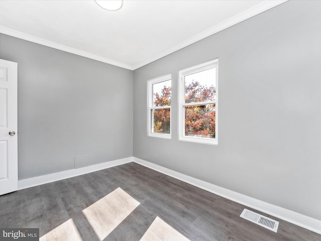 empty room with ornamental molding and dark hardwood / wood-style floors