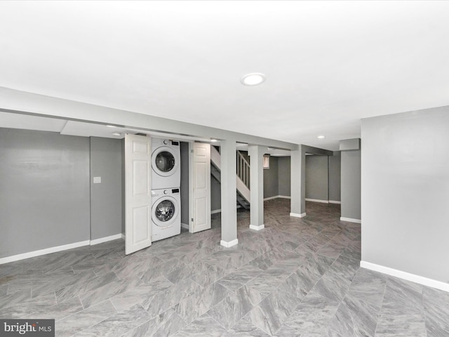 basement featuring stacked washer and clothes dryer