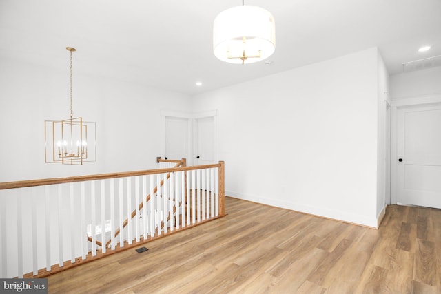 hall with a chandelier and wood-type flooring