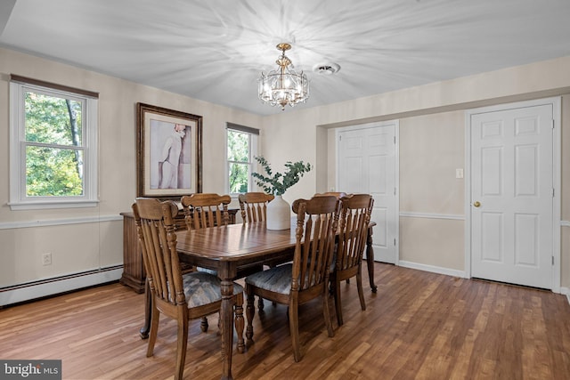 dining area with a healthy amount of sunlight, a chandelier, wood-type flooring, and a baseboard radiator