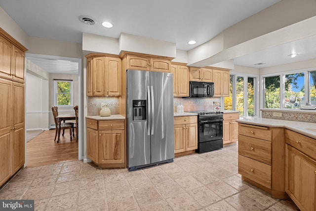 kitchen with black appliances, decorative backsplash, and a healthy amount of sunlight