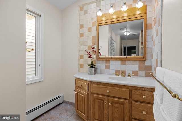 bathroom with vanity, decorative backsplash, a baseboard heating unit, and tile patterned flooring