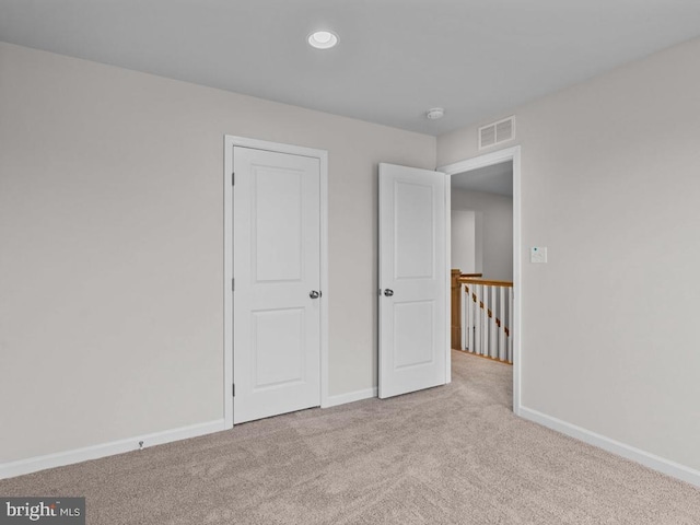 unfurnished bedroom with light colored carpet