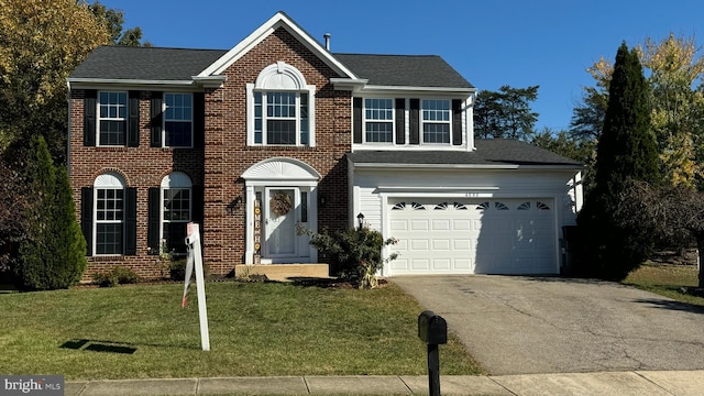 colonial inspired home featuring a front yard and a garage