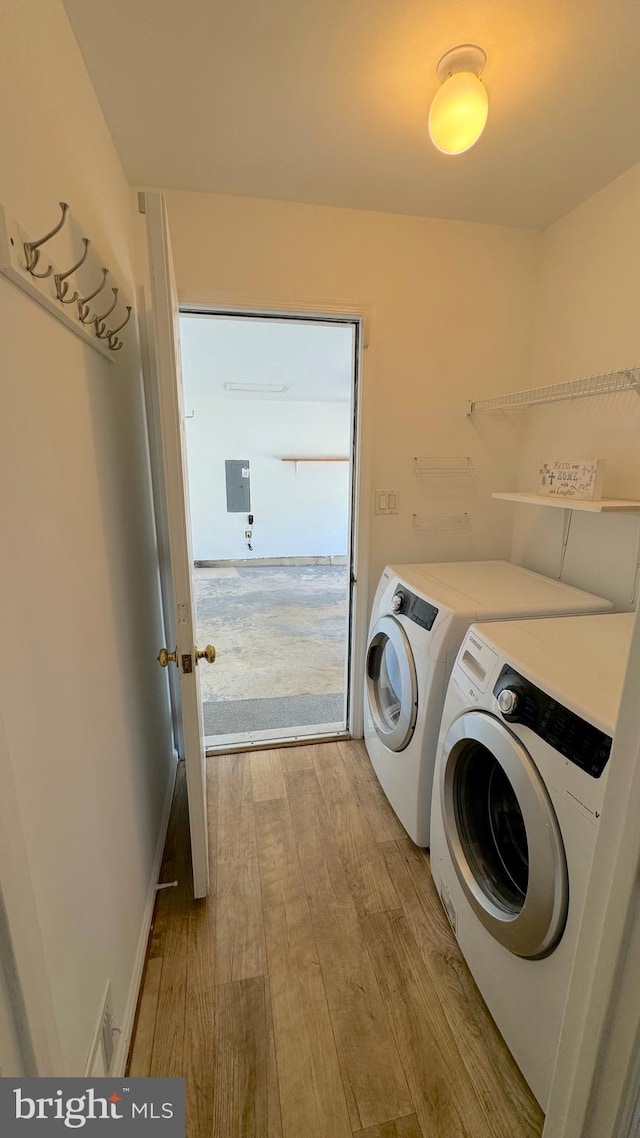 washroom with light hardwood / wood-style flooring and washing machine and dryer