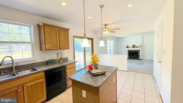 kitchen featuring sink, dishwasher, a fireplace, a center island, and light tile patterned floors