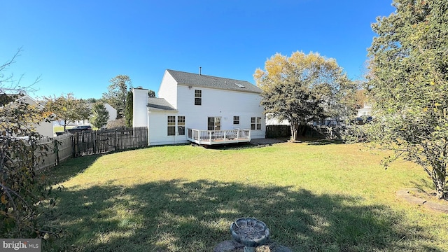 rear view of property with a deck and a yard