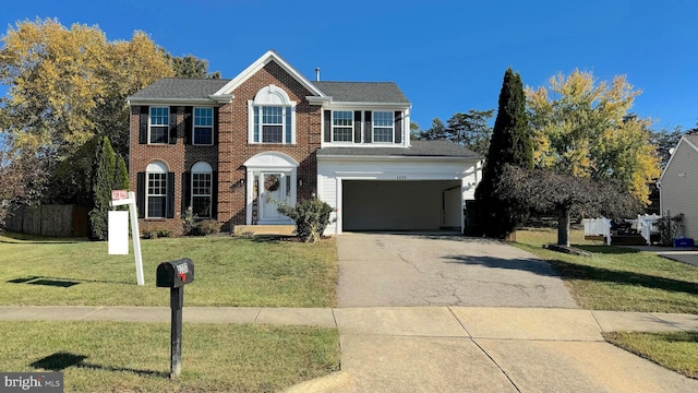 colonial home with a front lawn and a garage