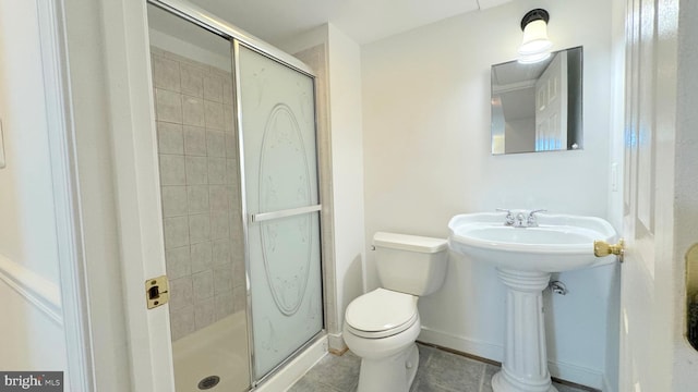 bathroom featuring a shower with door, toilet, and tile patterned flooring