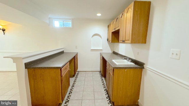 kitchen with sink, light tile patterned floors, and a breakfast bar area