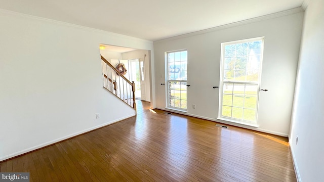 spare room featuring ornamental molding and hardwood / wood-style floors