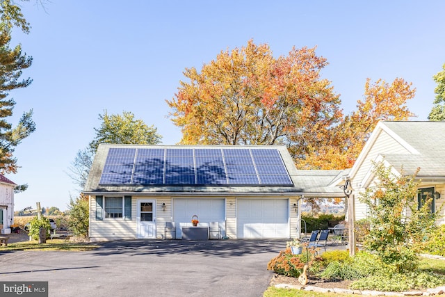 view of front of property with solar panels and a garage