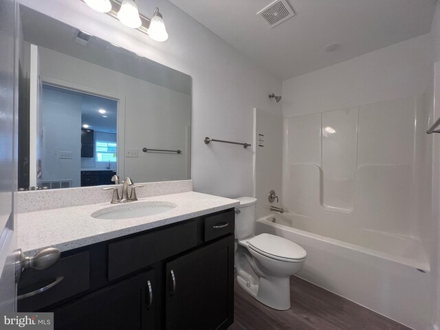 full bathroom featuring vanity, hardwood / wood-style floors, bathing tub / shower combination, and toilet