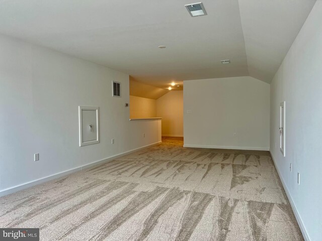 carpeted spare room featuring vaulted ceiling