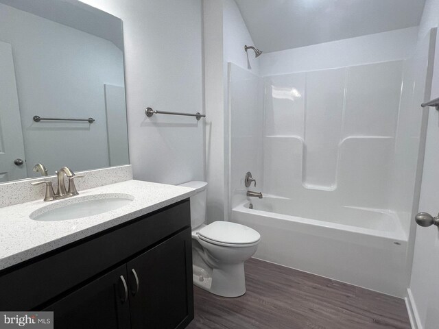 full bathroom with toilet, hardwood / wood-style floors, vanity, and shower / bath combination