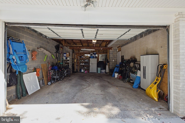 garage with a garage door opener and white refrigerator