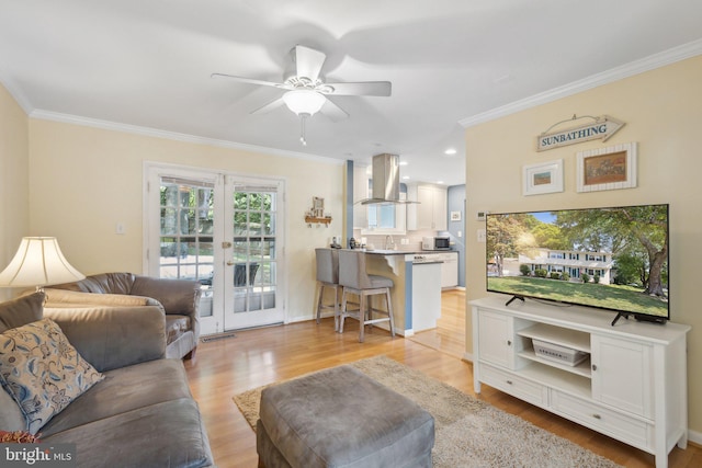 living room with ceiling fan, french doors, light hardwood / wood-style floors, and ornamental molding