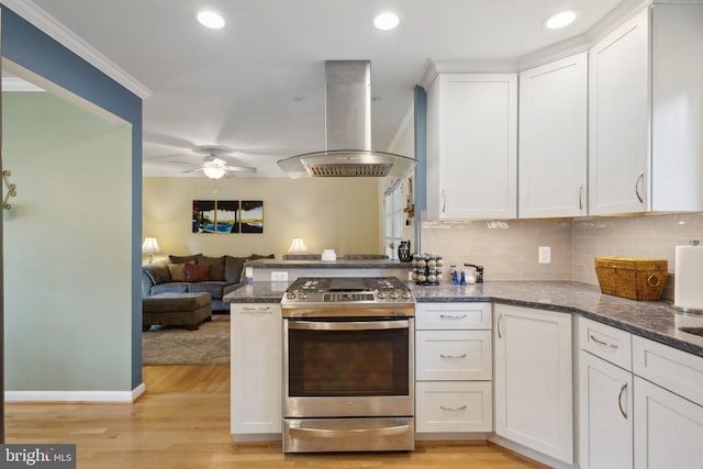 kitchen featuring stainless steel range, island range hood, and white cabinetry