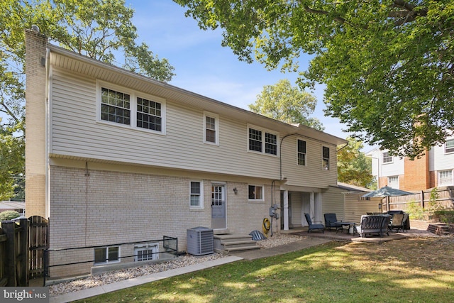 back of property featuring central air condition unit, a yard, and a patio