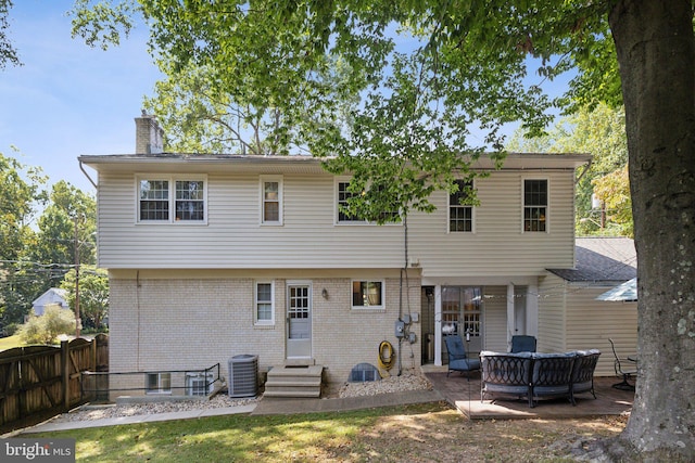 back of property with an outdoor living space, a patio, and central AC unit