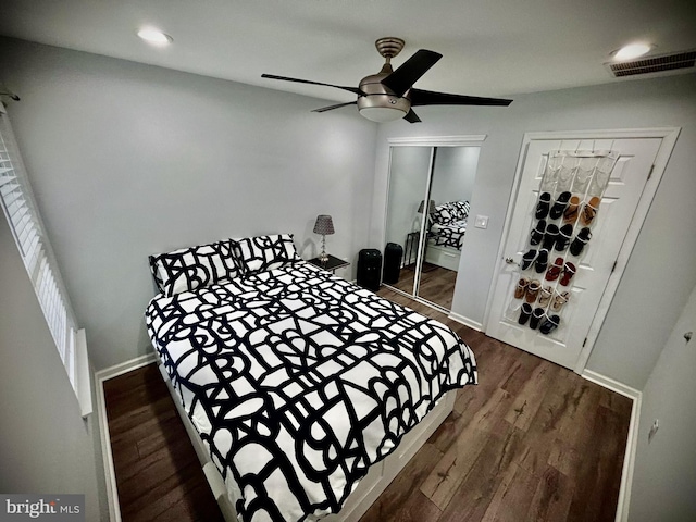 bedroom featuring dark wood-type flooring, a closet, and ceiling fan