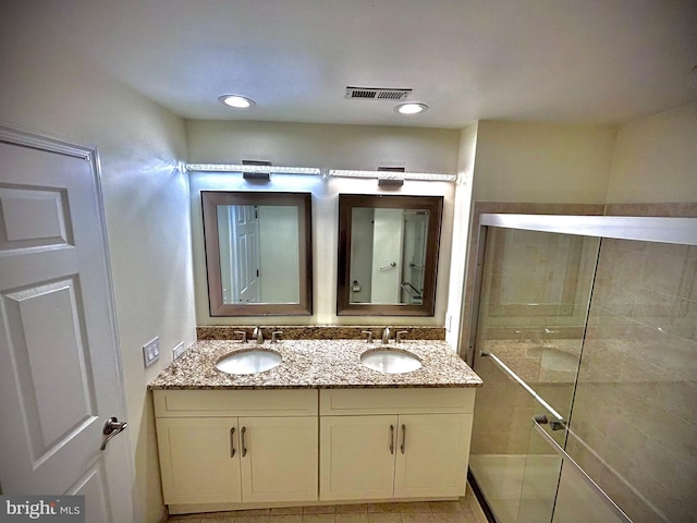 bathroom with vanity, tile patterned flooring, and tiled shower