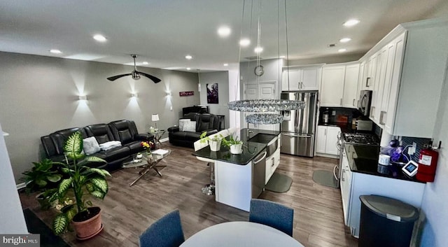 kitchen featuring white cabinetry, appliances with stainless steel finishes, a center island, and a kitchen breakfast bar