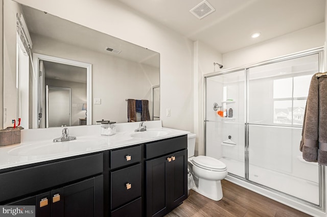 bathroom featuring hardwood / wood-style floors, vanity, toilet, and walk in shower