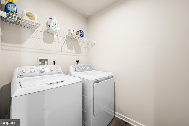 laundry area featuring washing machine and dryer and dark hardwood / wood-style floors