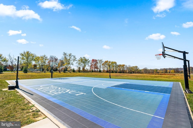 view of basketball court with a yard