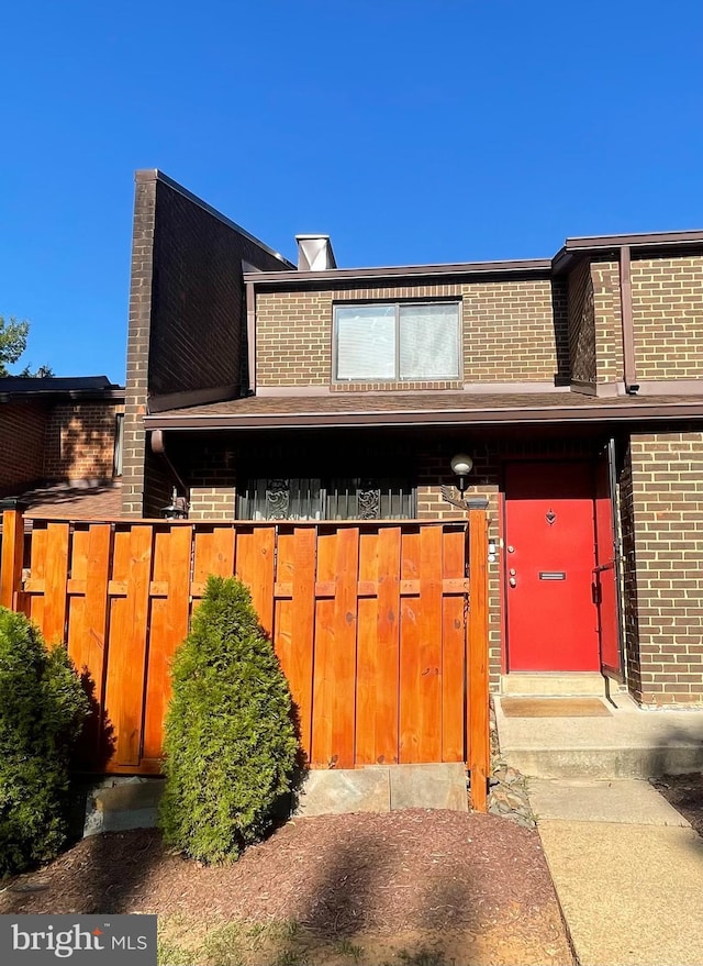 view of front of house featuring brick siding and fence private yard