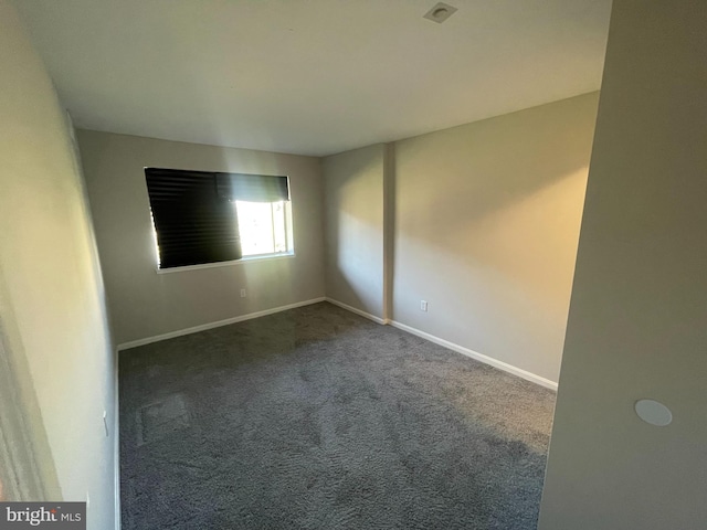 empty room featuring dark carpet