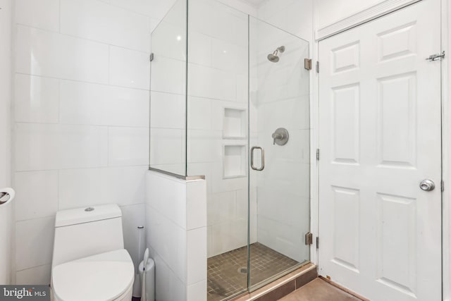 bathroom with a shower with door and toilet