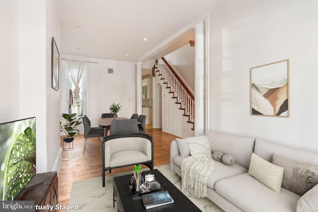 living room featuring decorative columns and light wood-type flooring