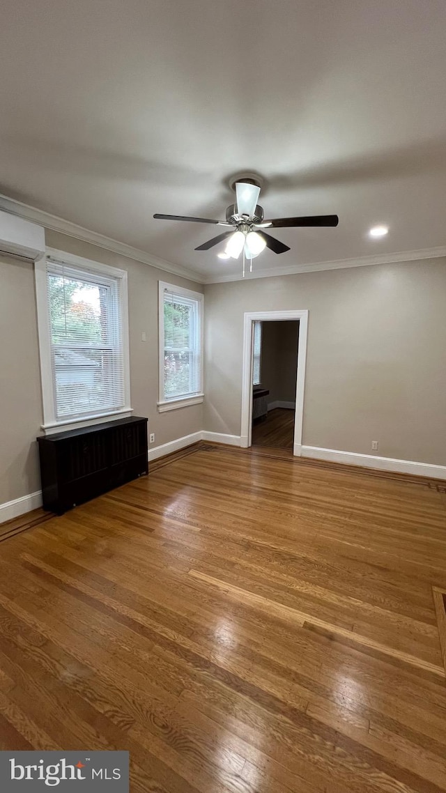 empty room featuring ceiling fan, wood-type flooring, and ornamental molding