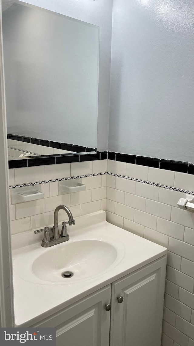 bathroom with vanity and tile walls