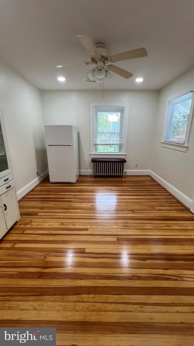 interior space with light hardwood / wood-style floors, radiator, and ceiling fan